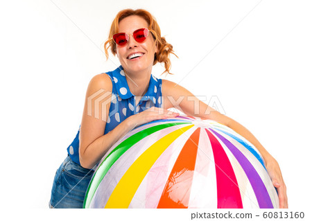 beautiful girl in sunglasses holds an inflatable big ball on a white background beautiful girl in sunglasses holds an inflatable big ball on a white background 60813160