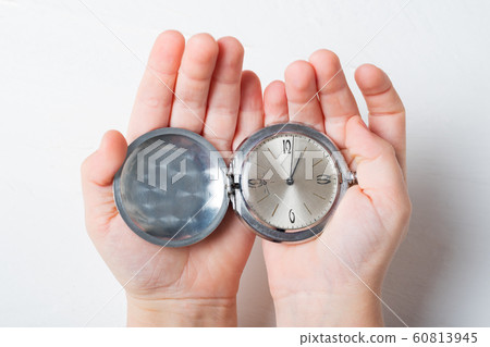 Open pocket watch in children's palms on a light Open pocket watch in children's palms on a light 60813945