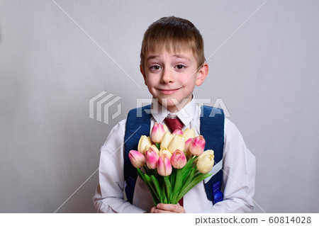 Schoolboy with a school bag holding a bouquet of 60814028