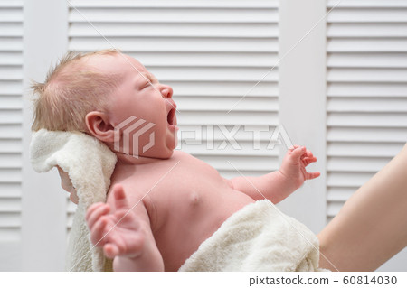 Crying blond baby without clothes. Infant colic. 60814030