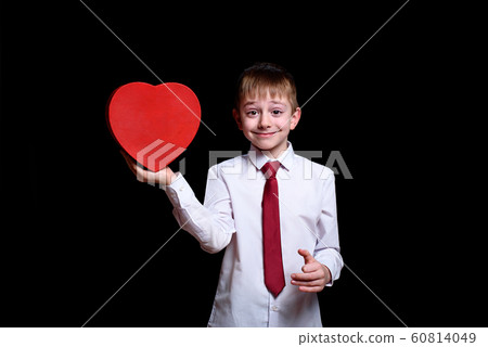 Smiling boy holding red heart shaped box. Isolate 60814049