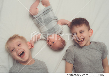 Two older brothers and youngest baby in a white 60814070