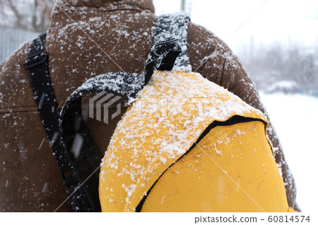 A rustic man is walking down the street in winter 60814574