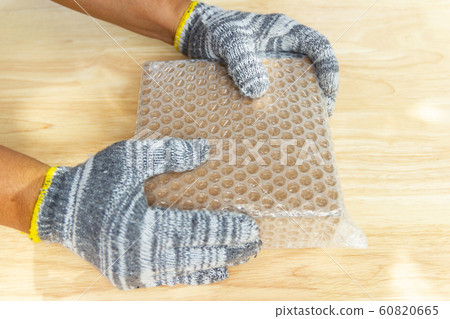 hand of man hold bubble wrap, for protection hand of man hold bubble wrap, for protection 60820665