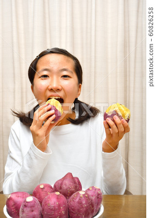 Girls eating sweet potatoes 60826258