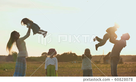 Happy parents of 4 children toss up their children. Happy parents of 4 children toss up their children. 60828078