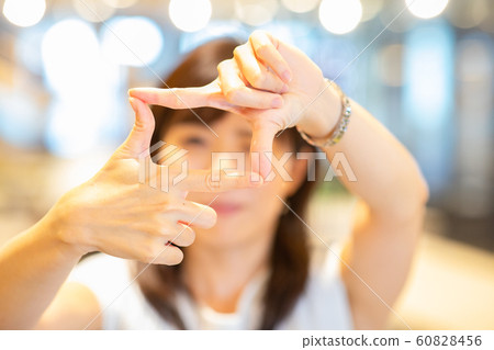 Young woman making hand window Young woman making hand window 60828456