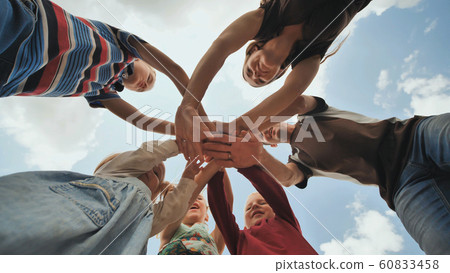 A young family of six join hands together. The concept of a strong and friendly family. 60833458