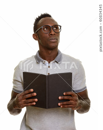 Young black African man holding book while thinking 60834345