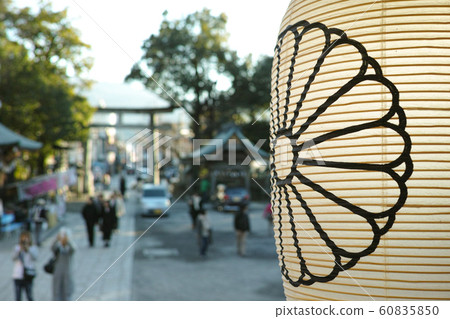 A lantern in front of a defocussed background of shrine goers in Japan 60835850