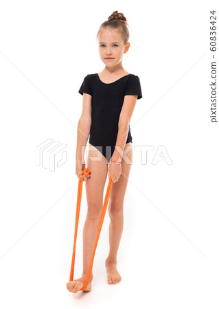 young gymnast child doing stretching with elastic tape on a white background young gymnast child doing stretching with elastic tape on a white background 60836424