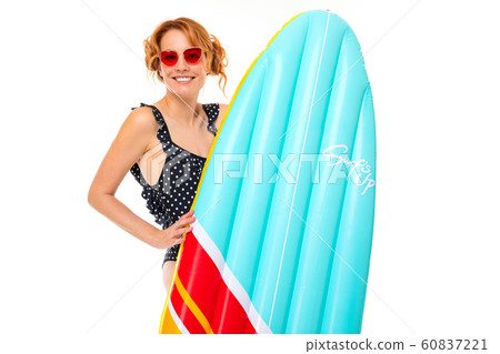 girl in retro swimsuit and glasses with a surfboard on a white background 60837221