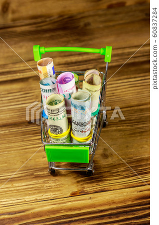 Shopping cart with money from different countries 60837284