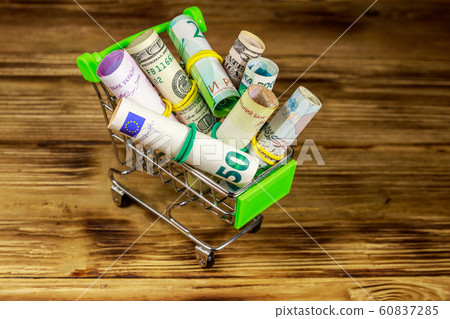 Shopping cart with money from different countries Shopping cart with money from different countries 60837285