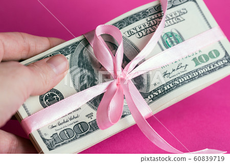 a bundle of dollars tied with a pink ribbon a bundle of dollars tied with a pink ribbon 60839719