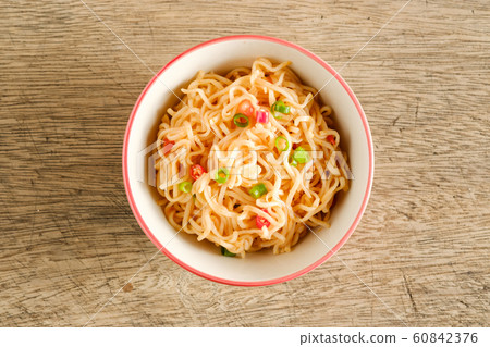 A cup of instant noodles placed on a wooden table 60842376