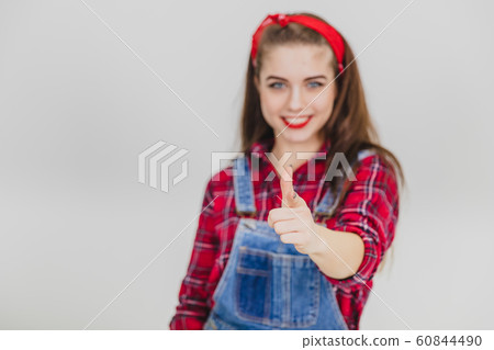 Blurred pretty smiling girl joyfully pointing her fingers at the camera. 60844490