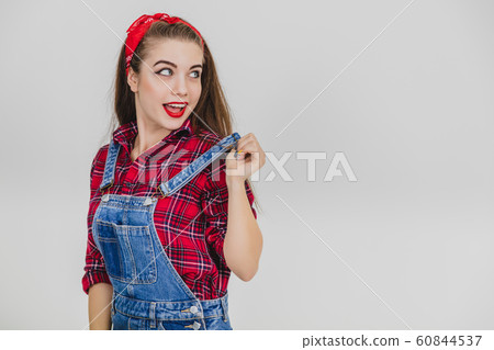 Cute girl standing, pulling up her suspender, looking lovely up. Cute girl standing, pulling up her suspender, looking lovely up. 60844537