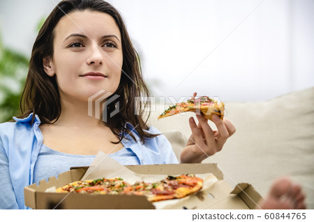Caucasion woman eats delicious pizza, isolated, at home. Close up. Copy space. 60844765