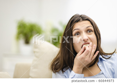 Portrait of pretty, involved, cheerful woman with straight black hair, who is eating pop corn. Close up. Portrait of pretty, involved, cheerful woman with straight black hair, who is eating pop corn. Close up. 60844973