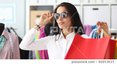 Pretty woman touching sunglasses 60853615