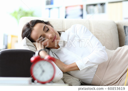 Sleeping businesswoman on sofa 60853619
