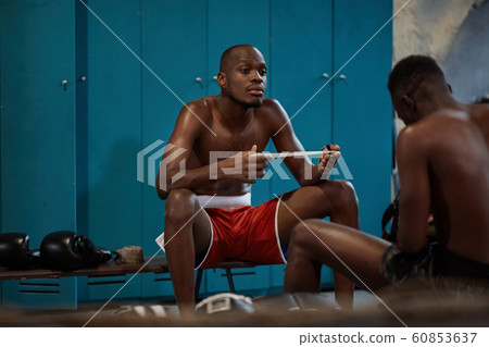 Sportsmen sitting in locker room 60853637