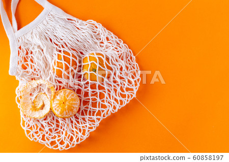 Flat lay tangerines in a mesh shopping bag, zero waste concept 60858197