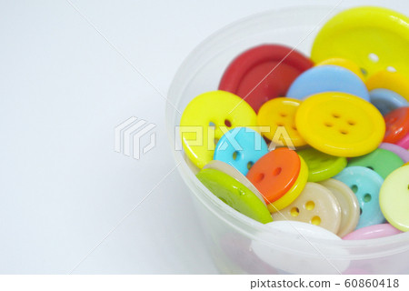 Colourful and various size of cloth button inside clear plastic container isolated on white background Colourful and various size of cloth button inside clear plastic container isolated on white background 60860418