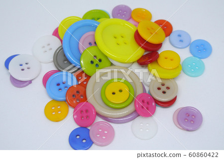 Colourful and various size of cloth button inside clear plastic container isolated on white background Colourful and various size of cloth button inside clear plastic container isolated on white background 60860422