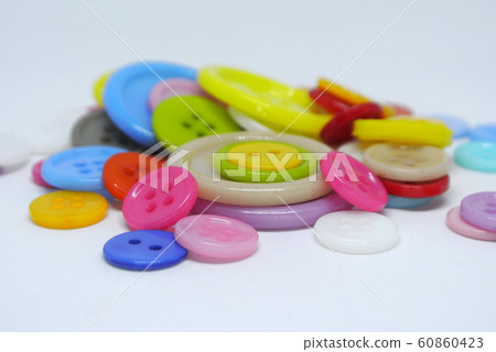 Colourful and various size of cloth button inside clear plastic container isolated on white background Colourful and various size of cloth button inside clear plastic container isolated on white background 60860423