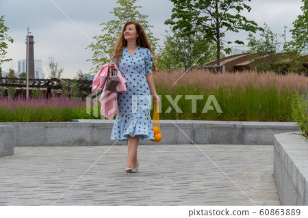 Young positive Woman Holding Oranges Young positive Woman Holding Oranges 60863889