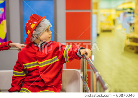 Expressive cute toddler with fireman outfit playing fireman 60870346