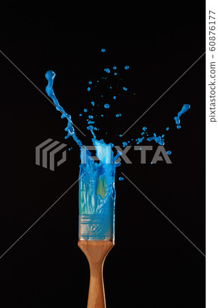 Brushes with spreading blue paint on blank black background 60876177