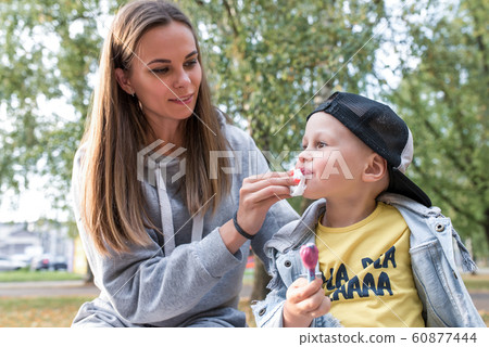 mother son, eat ice cream, wipe lips and face of child with napkin, care for her son, summer day park autumn, support for love happiness weekend. Rest with parent nature. Emotions purity hygiene. mother son, eat ice cream, wipe lips and face of child with napkin, care for her son, summer day park autumn, support for love happiness weekend. Rest with parent nature. Emotions purity hygiene. 60877444