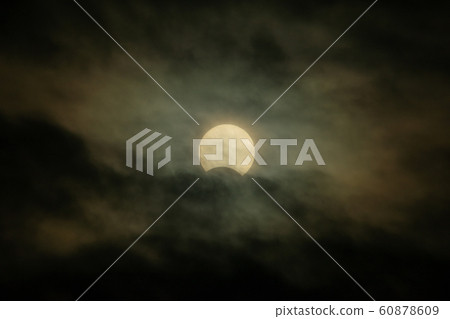 Partial solar eclipse in cloudy sky December 26, 2019 Partial solar eclipse in cloudy sky December 26, 2019 60878609