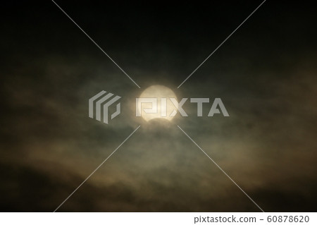 Partial solar eclipse in cloudy sky December 26, 2019 Partial solar eclipse in cloudy sky December 26, 2019 60878620