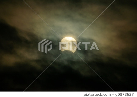 Partial solar eclipse in cloudy sky December 26, 2019 Partial solar eclipse in cloudy sky December 26, 2019 60878627
