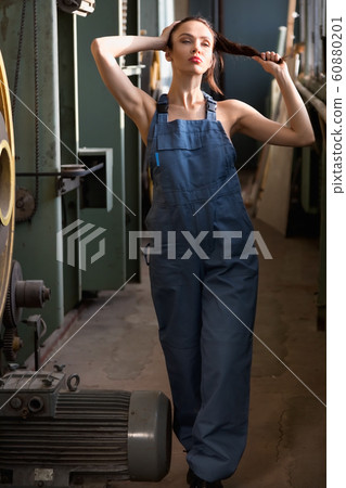 Attractive brunette girl dressed in overalls Attractive brunette girl dressed in overalls 60880201