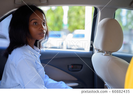 Young beautiful African Zulu businesswoman riding inside the car Young beautiful African Zulu businesswoman riding inside the car 60882435