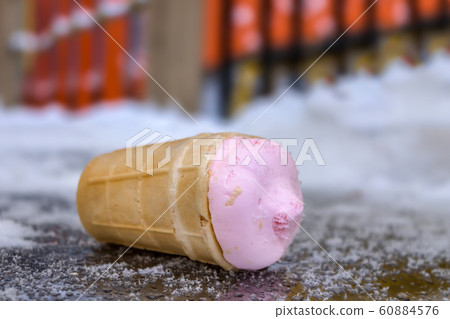 Fallen popsicles lie on a cold snowy surface in a park Fallen popsicles lie on a cold snowy surface in a park 60884576
