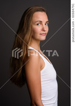 Young beautiful woman with long blond hair against gray backgrou Young beautiful woman with long blond hair against gray backgrou 60884791