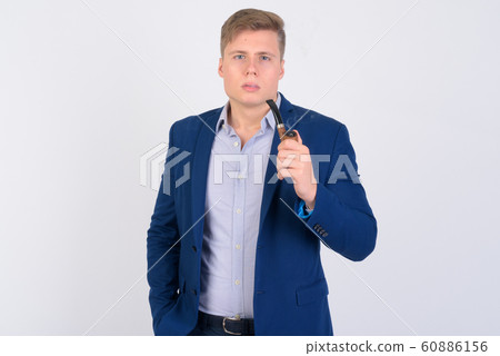 Portrait of young handsome blonde businessman smoking pipe Portrait of young handsome blonde businessman smoking pipe 60886156