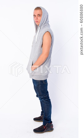 Full body shot profile view of young bald rebellious man looking at camera Full body shot profile view of young bald rebellious man looking at camera 60886880