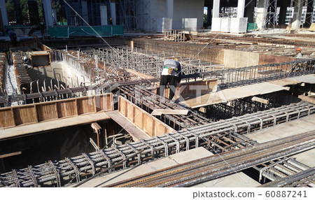 Construction workers fabricating steel reinforcement bar and timber formwork at the construction site. The basic method to create reinforced concrete structure.  60887241