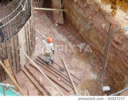 Construction workers fabricating steel reinforcement bar and timber formwork at the construction site. The basic method to create reinforced concrete structure.  60887257