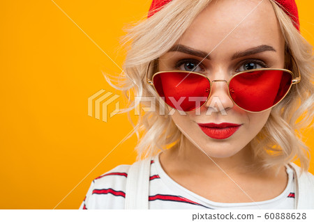 Portrait of beautiful young woman with short blonde curly hair and bright makeup in white overalls Portrait of beautiful young woman with short blonde curly hair and bright makeup in white overalls 60888628
