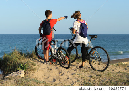boy and young woman on a Bicycle on a cliff by the sea boy and young woman on a Bicycle on a cliff by the sea 60889774