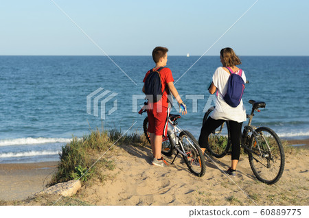 boy and young woman on a Bicycle on a cliff by the sea 60889775