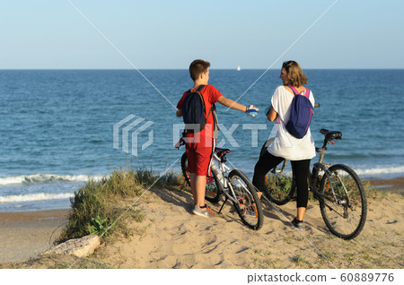 boy and young woman on a Bicycle on a cliff by the sea 60889776